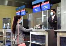 Emirates, DHA Implement Digital Verification of COVID-19 Medical Records for UAE Travellers Dubai Health Authority (DHA) interacting with a women at their kiosk
