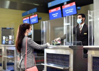 Emirates, DHA Implement Digital Verification of COVID-19 Medical Records for UAE Travellers Dubai Health Authority (DHA) interacting with a women at their kiosk